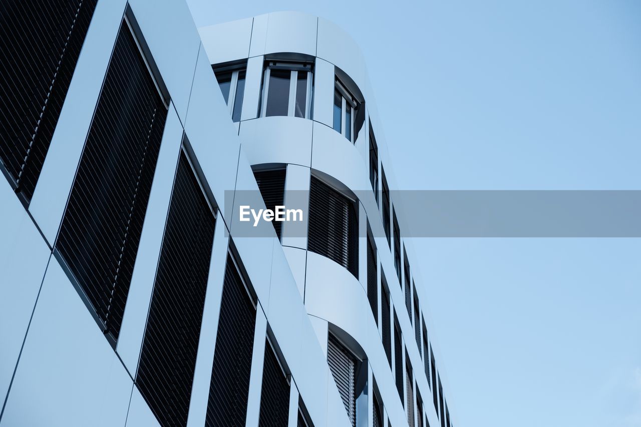 Low angle view of modern building against clear blue sky