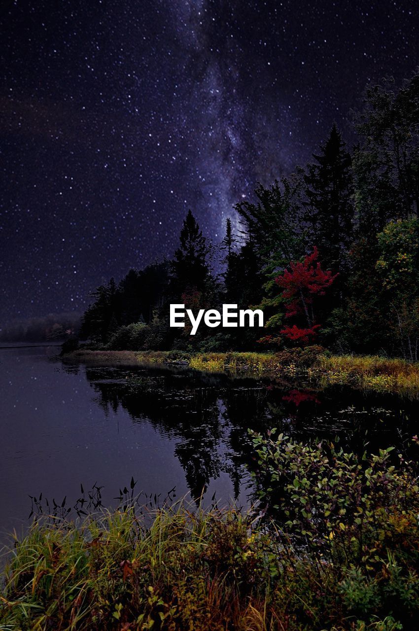 Scenic view of lake against sky at night