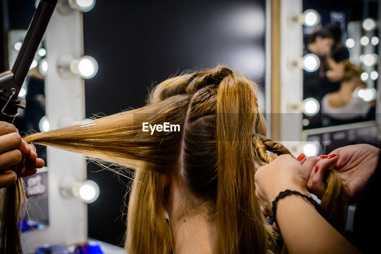 Cropped image of hairdressers with woman hair salon