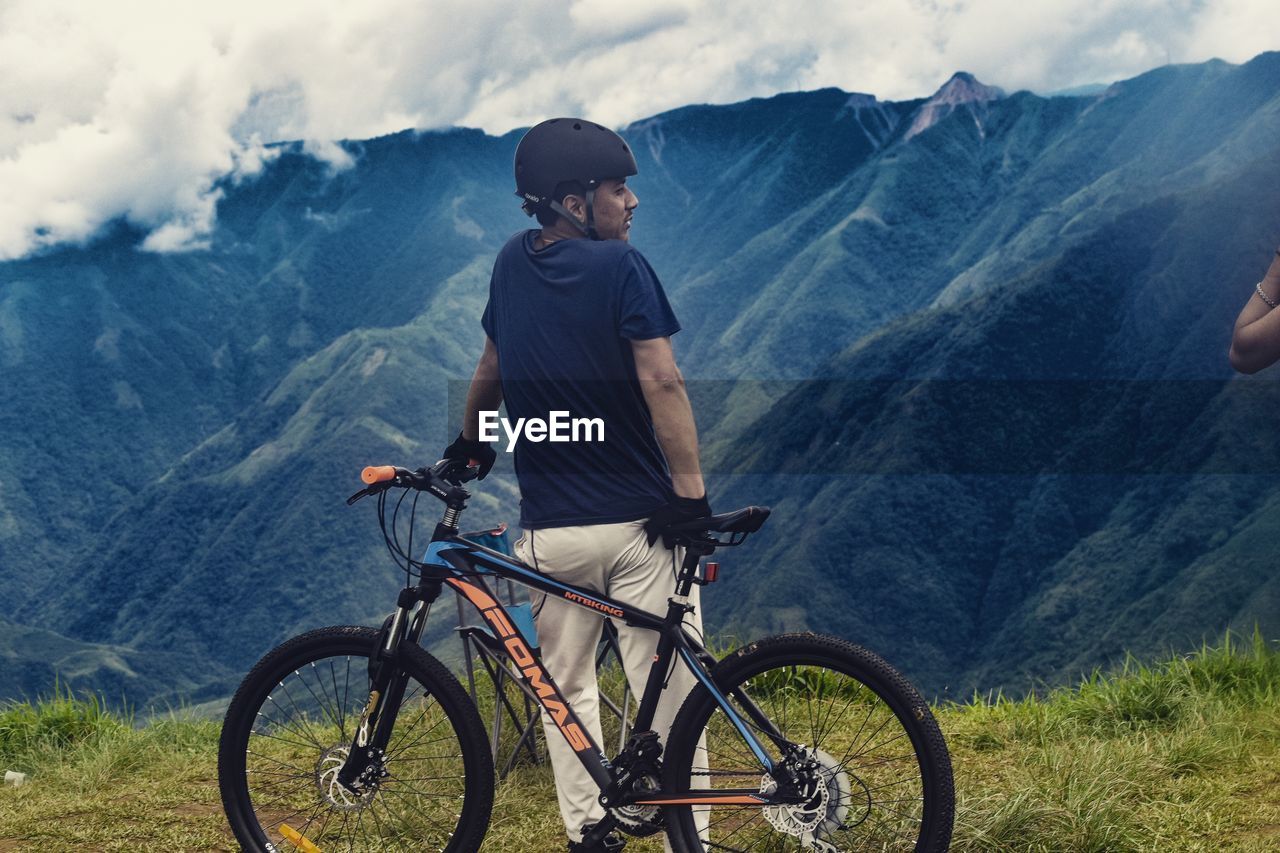 SIDE VIEW OF MAN RIDING BICYCLE ON MOUNTAIN