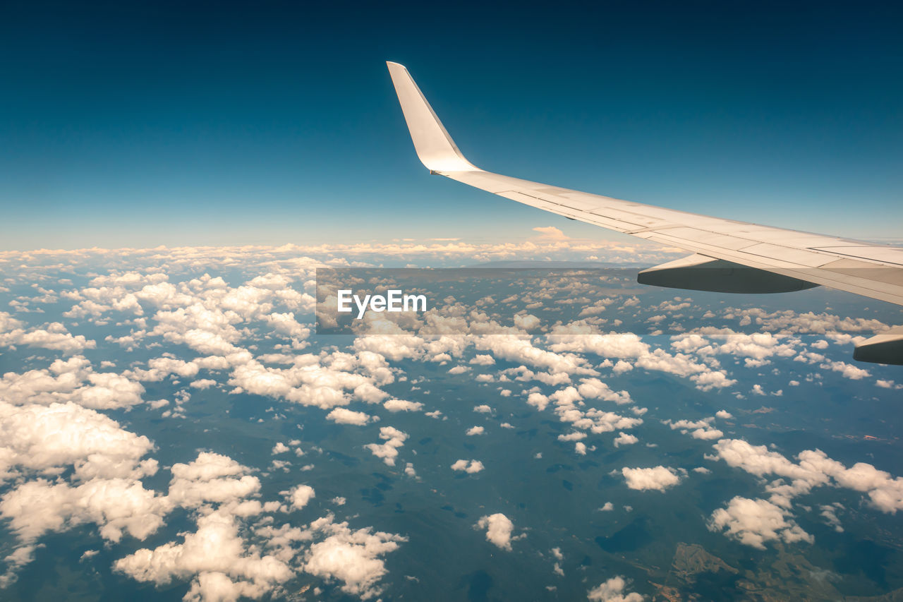 Aerial view of aircraft wing against sky