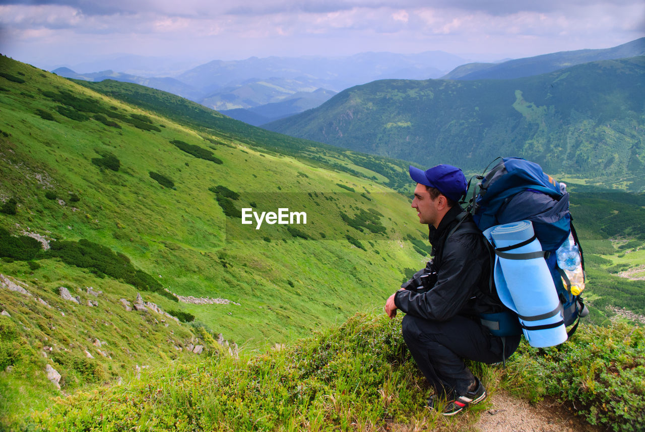 Side view of man with backpack looking at view