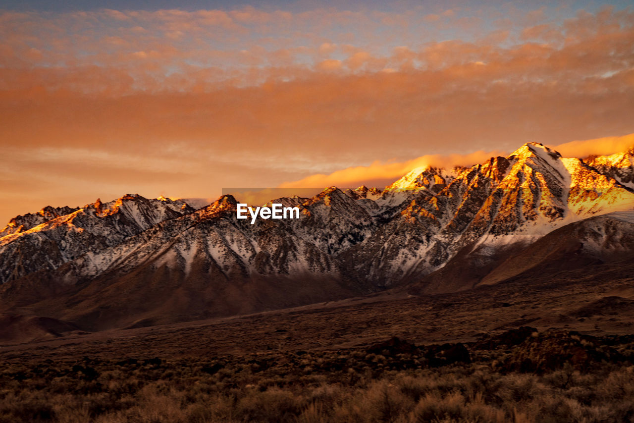 Scenic view of snowcapped mountains against sky during sunset