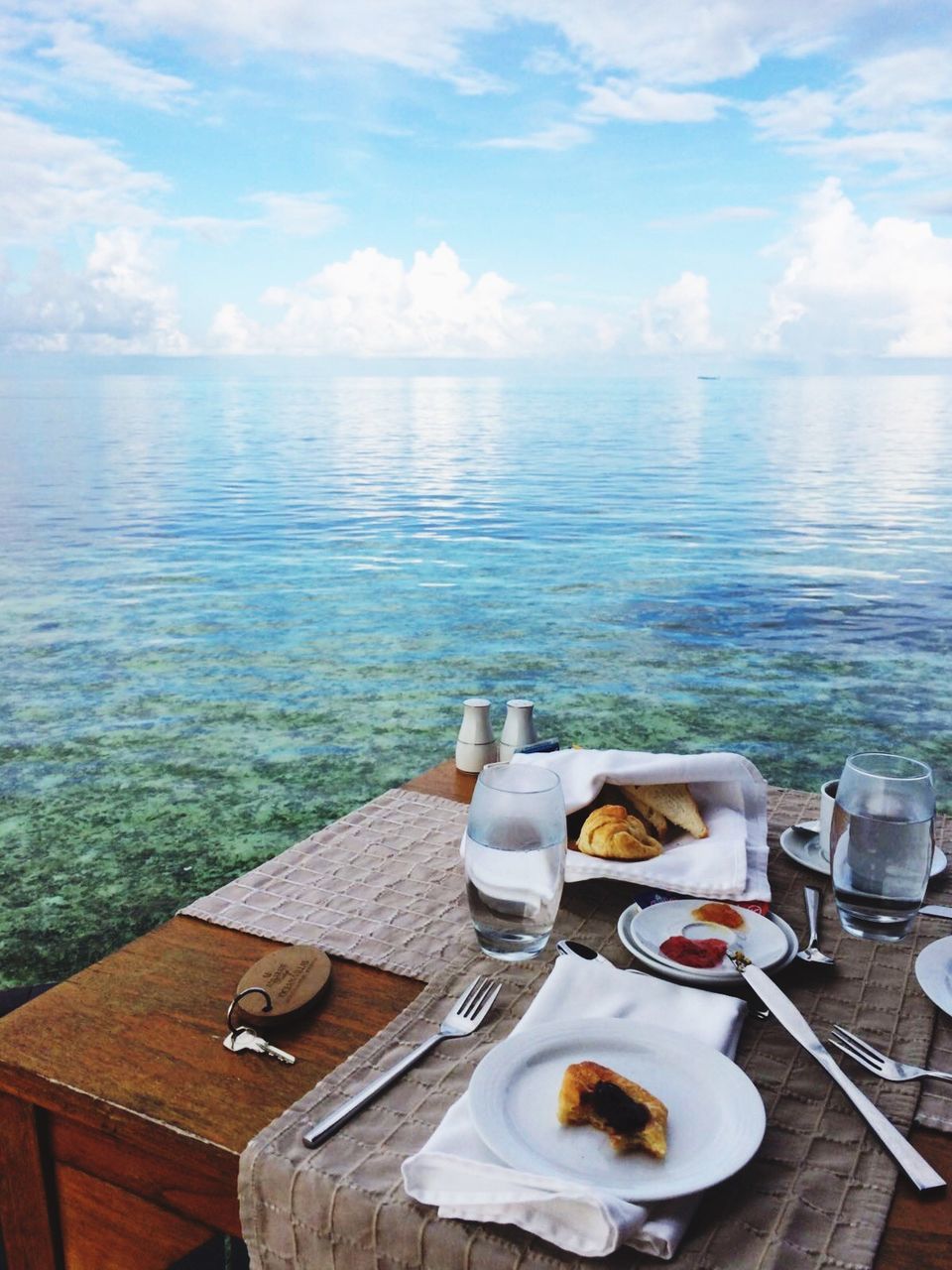 Breakfast on table by sea against sky