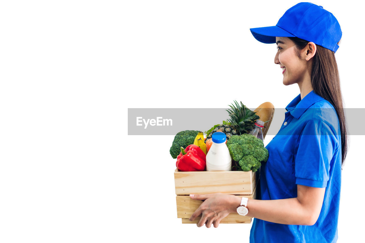 SIDE VIEW OF A WOMAN HOLDING ICE CREAM