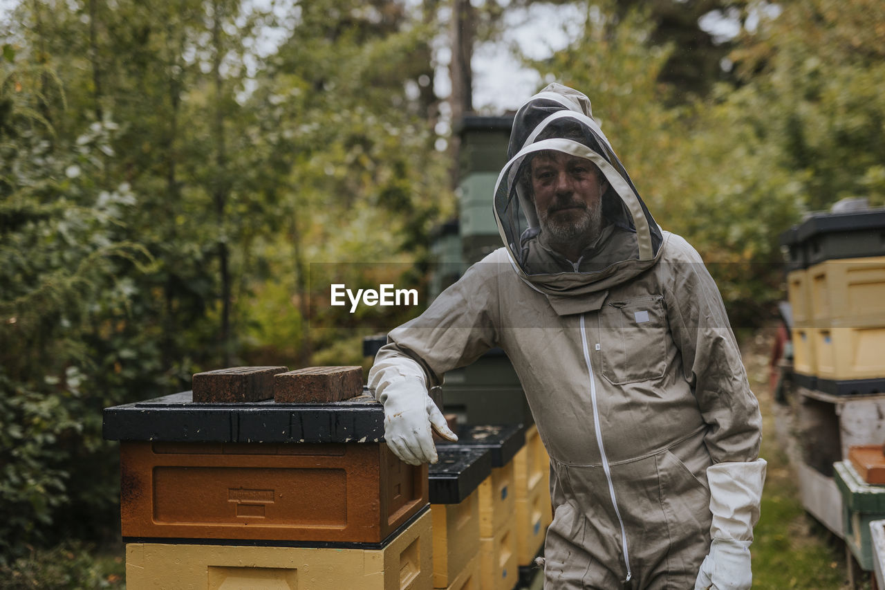 Beekeeper standing near beehive