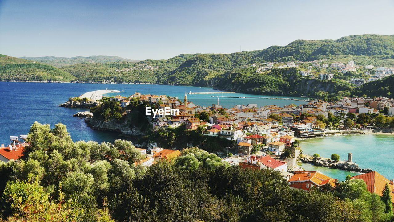 high angle view of buildings by sea against clear sky