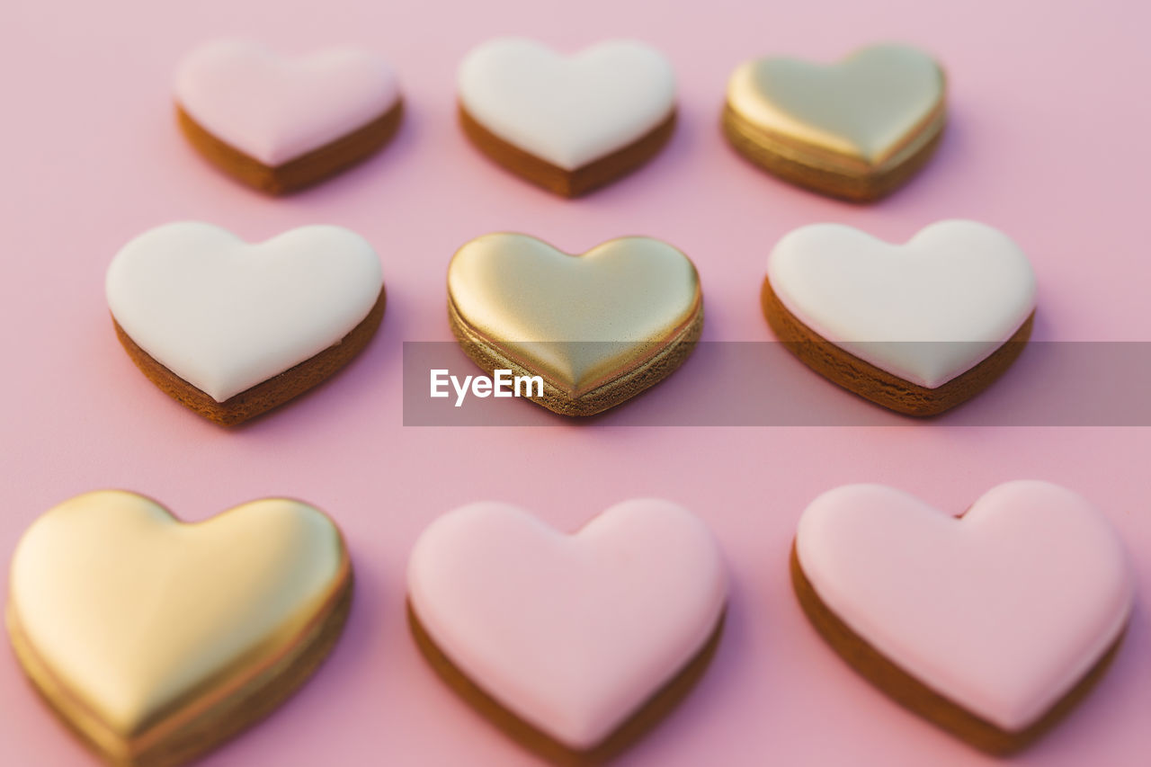 Pink background with sweet gingerbread heart cookies. high quality photo