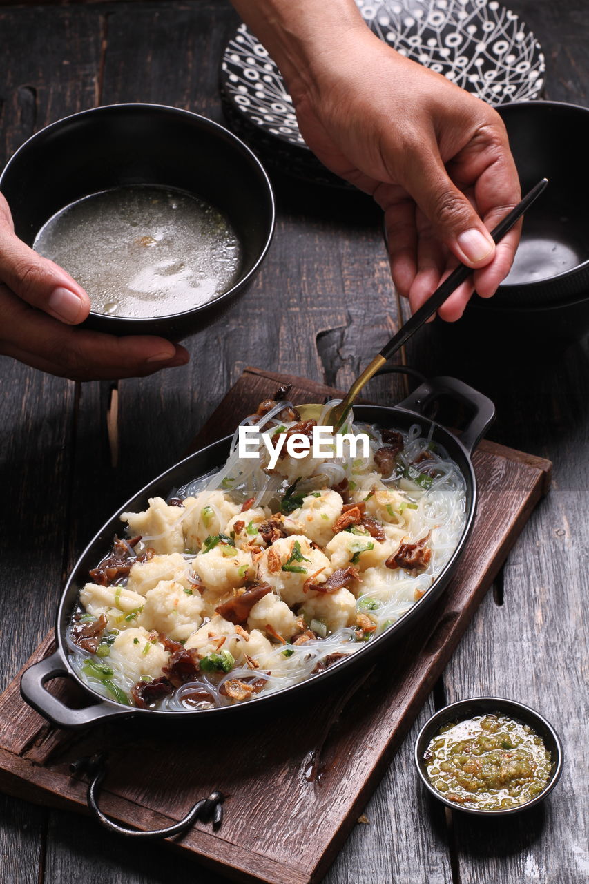 cropped hand of man preparing food on table