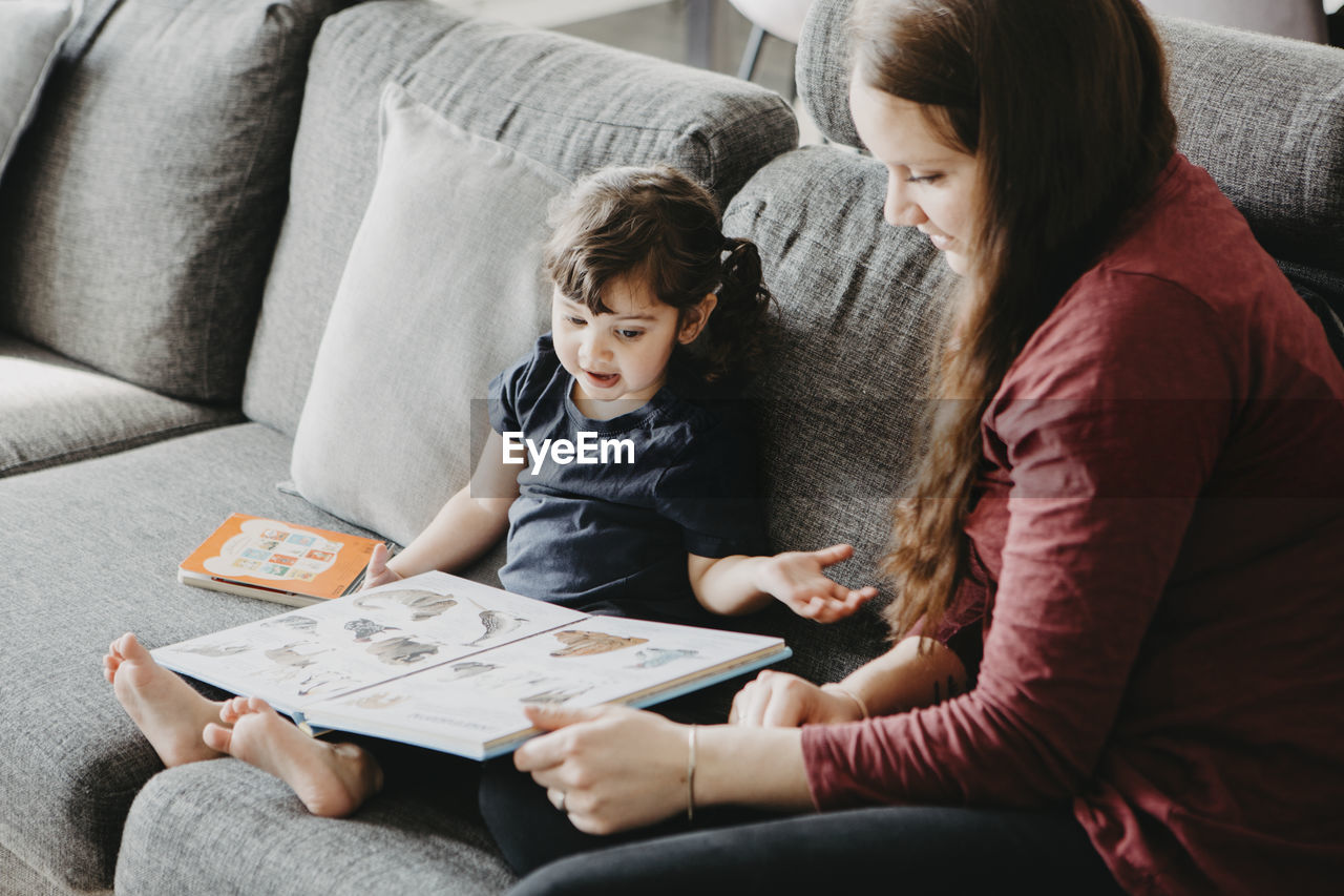 Mother with daughter reading book