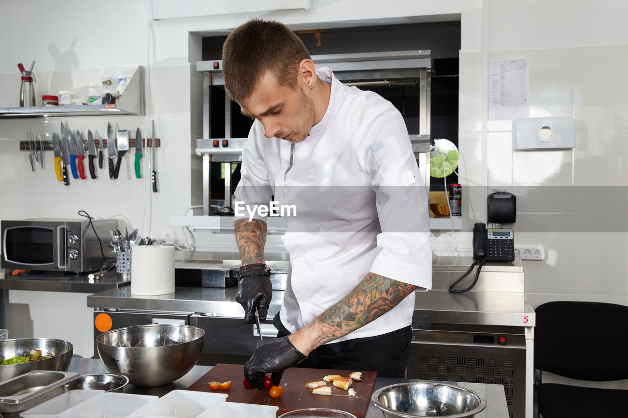 MAN PREPARING FOOD IN KITCHEN AT OFFICE