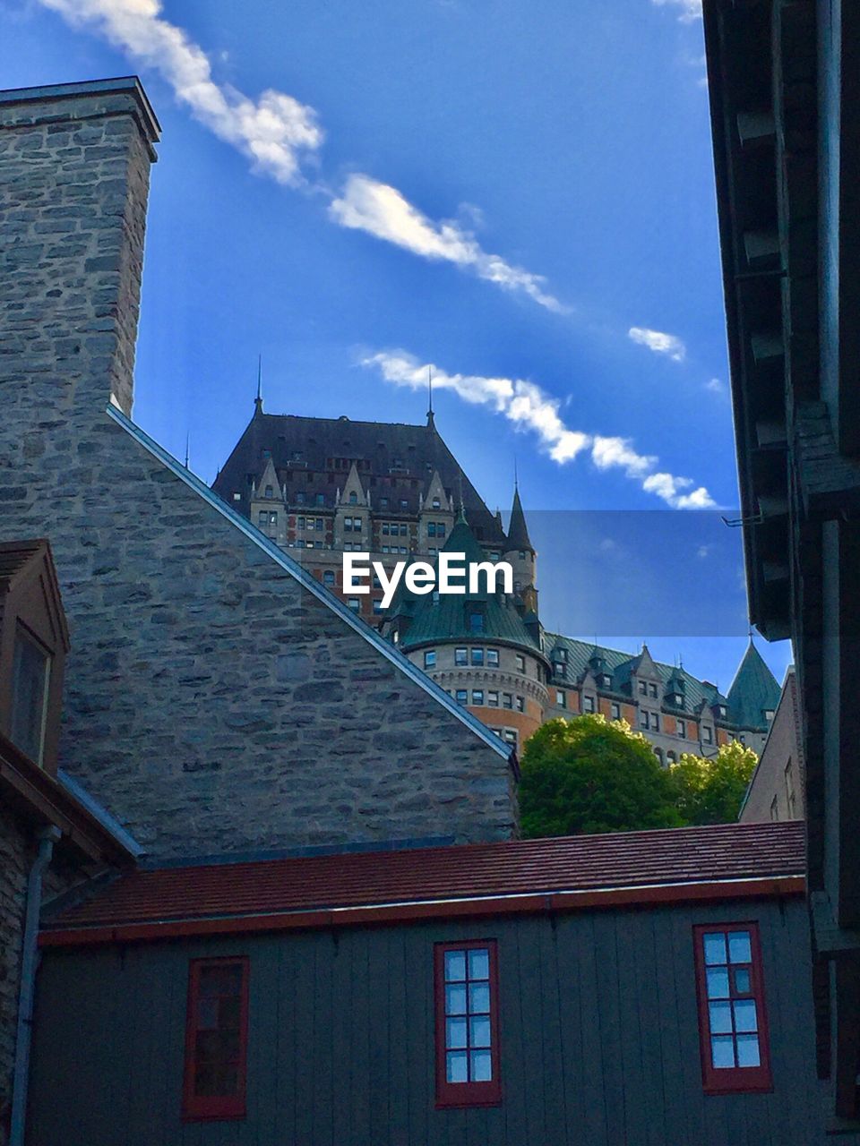 LOW ANGLE VIEW OF HOUSES AGAINST BLUE SKY