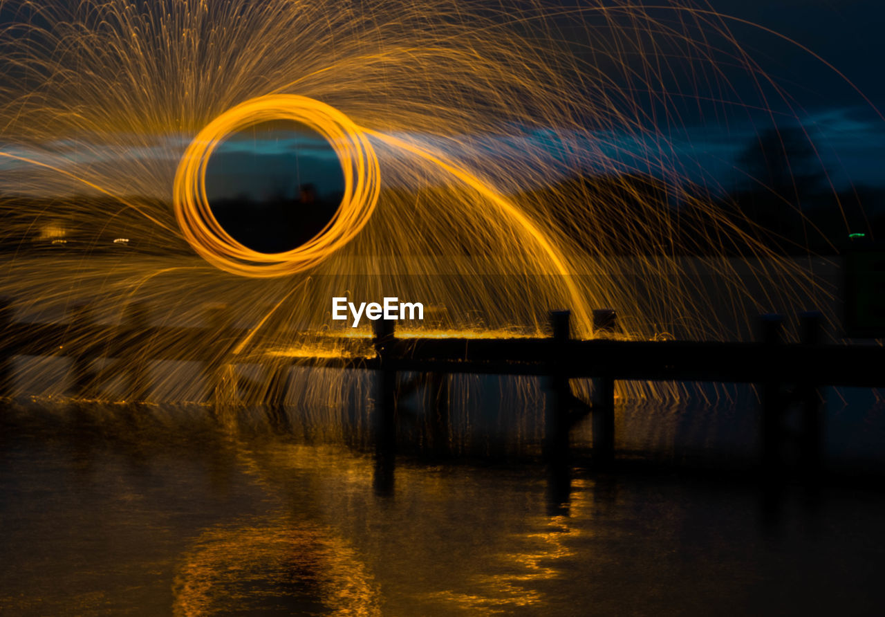 Light painting by lake against sky at night