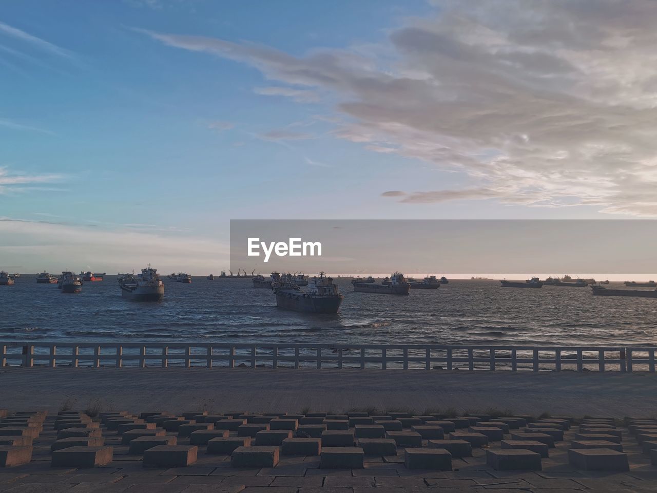 sky, water, horizon, sea, nature, cloud, shore, beach, architecture, coast, ocean, sunset, nautical vessel, land, travel destinations, beauty in nature, dusk, outdoors, built structure, sand, transportation, scenics - nature, body of water, travel, pier, no people, reflection, sunlight, ship, city, tranquility, tourism, day, evening, harbor, building exterior, tranquil scene