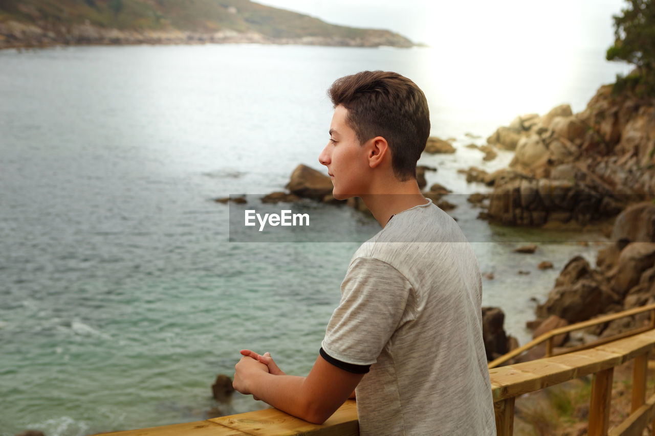 Side view of boy looking at sea