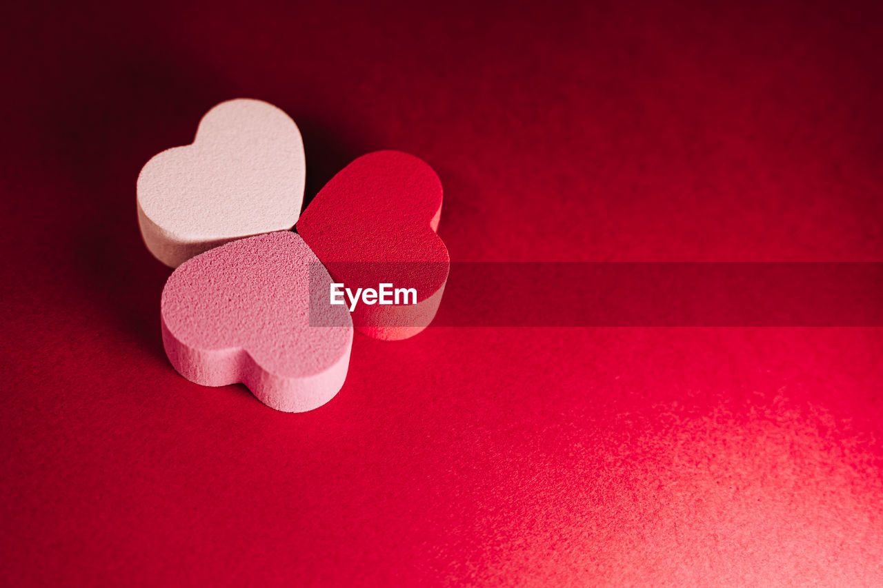 Top view of a three little hearts of sponges on a red background. valentine's  day concept