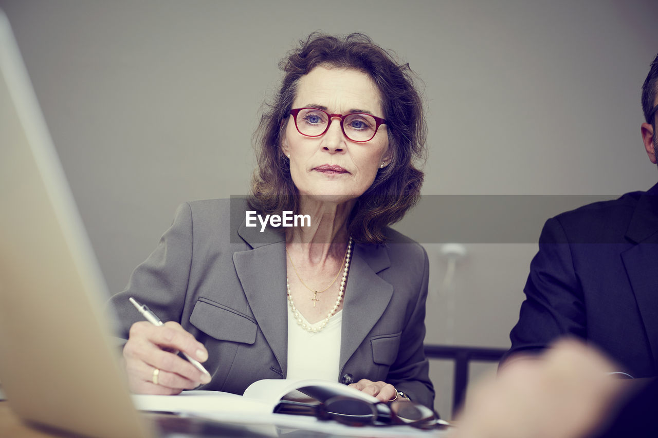 Confident senior female financial advisor working at law office