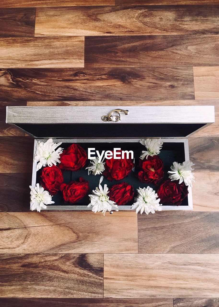 High angle view of flowers in container on hardwood floor