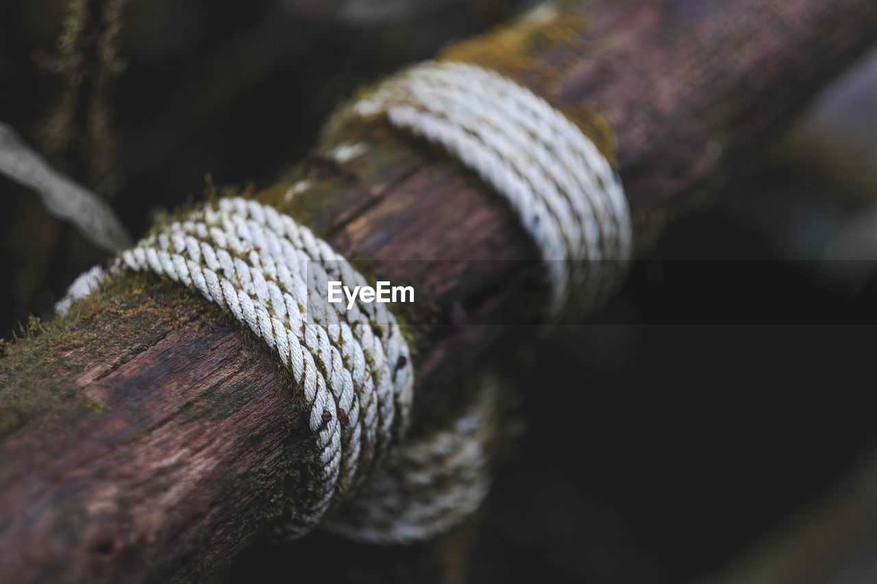 Close-up of rope tied up on wood