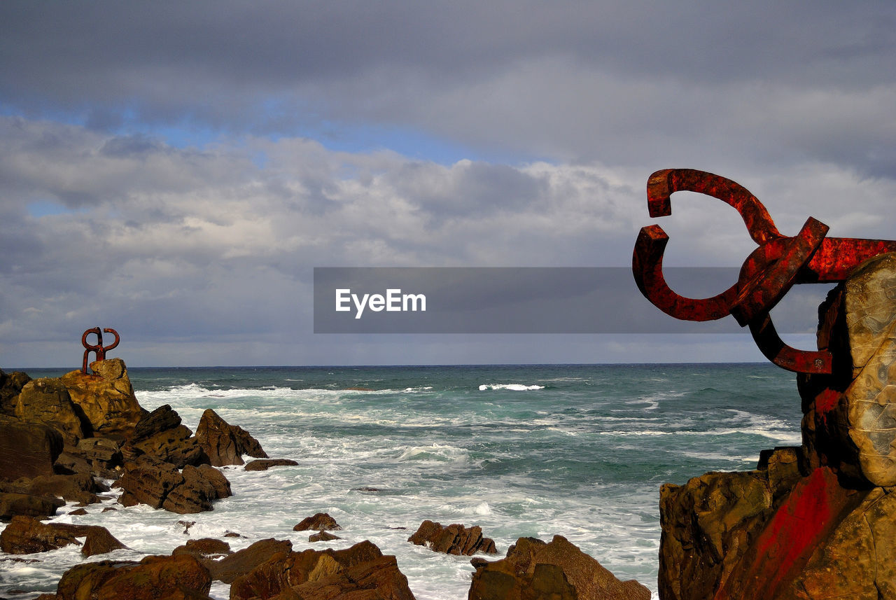 Scenic view of rocks on beach against sky