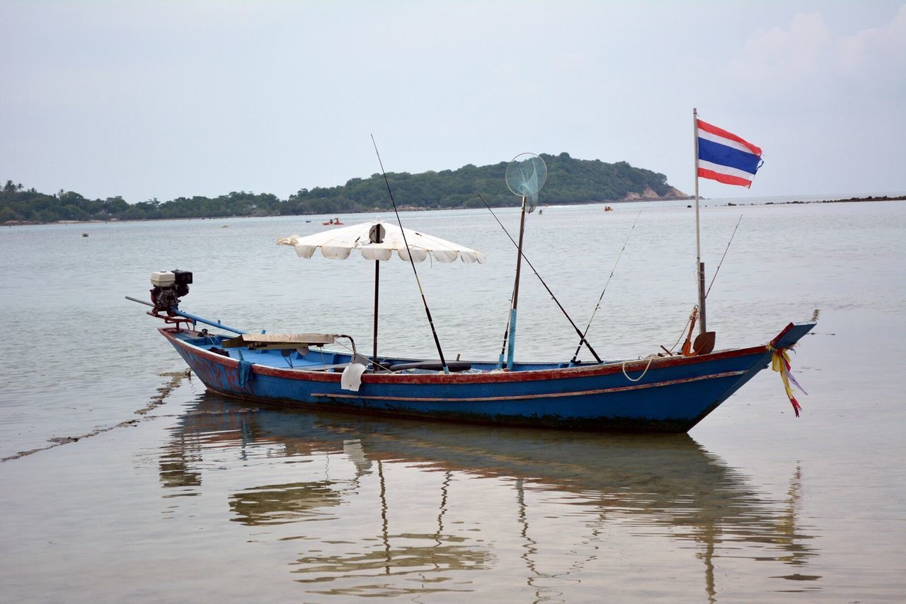 Boat moored on shore against sky