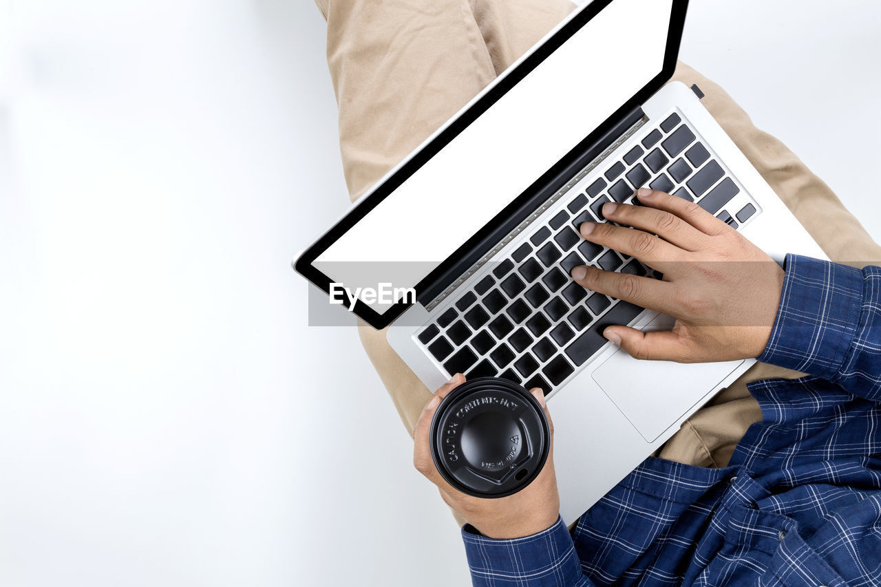 MIDSECTION OF MAN USING LAPTOP