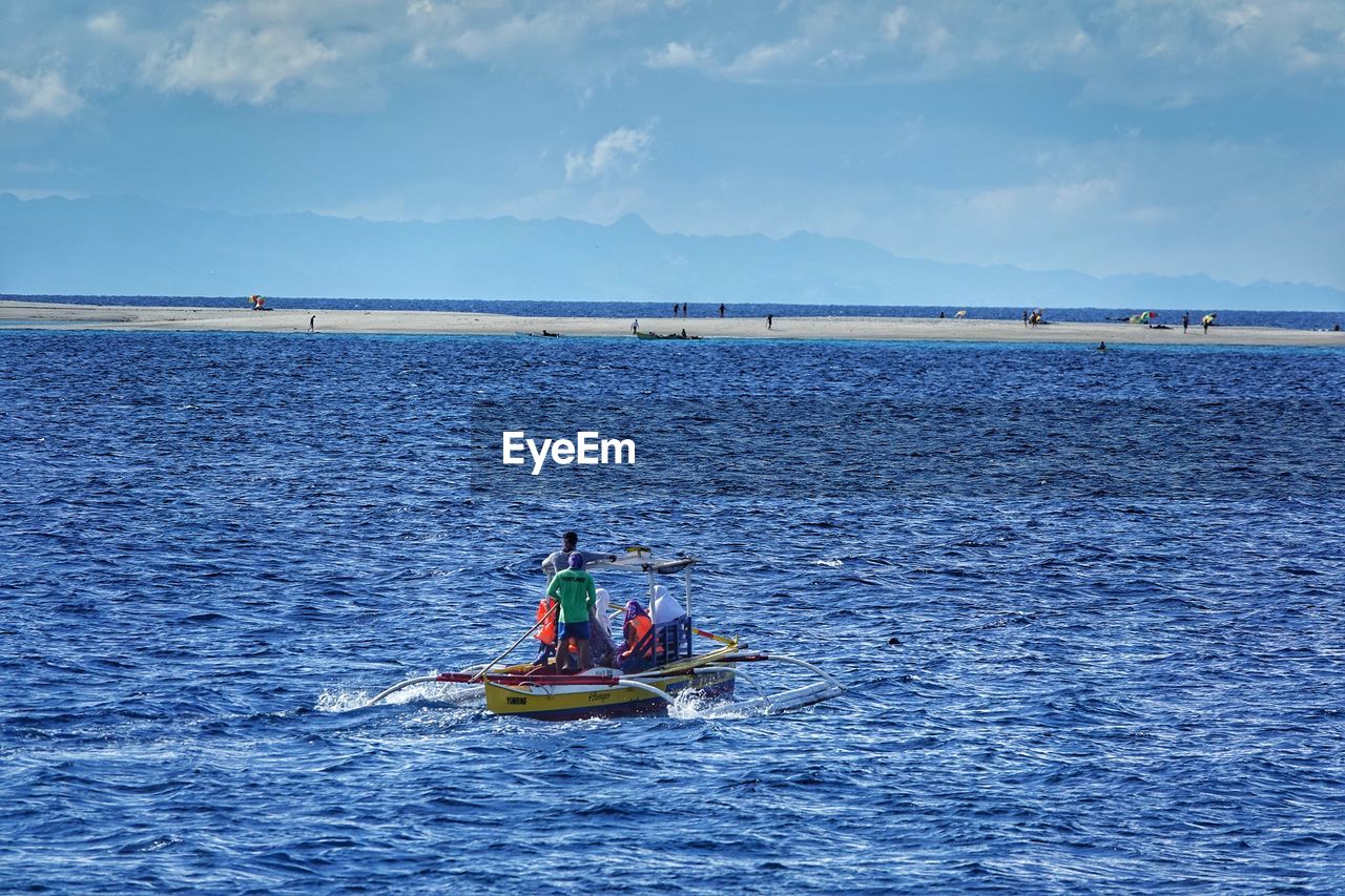 PEOPLE IN SEA AGAINST SKY