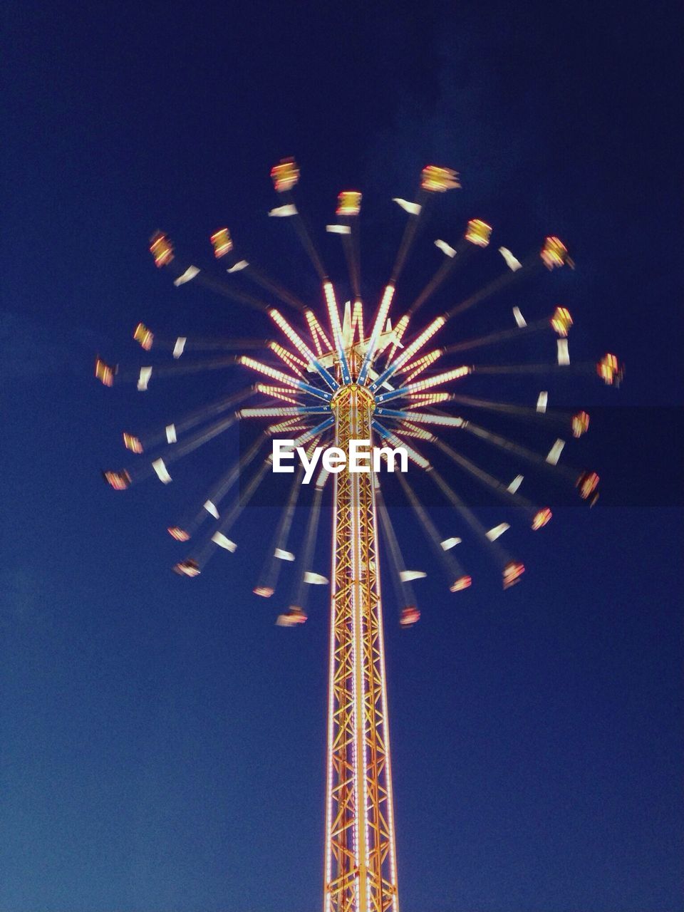 Illuminated swing ride against night sky