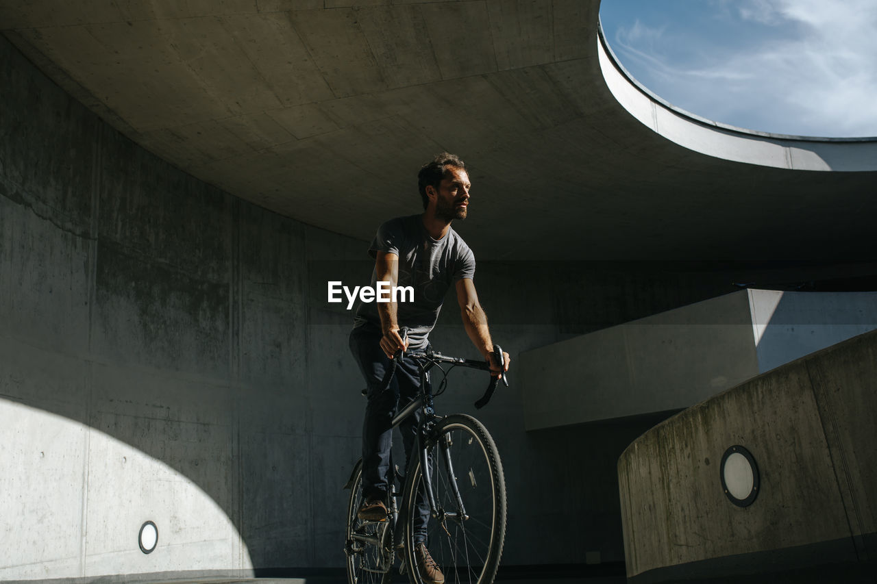 Man riding bicycle on bridge