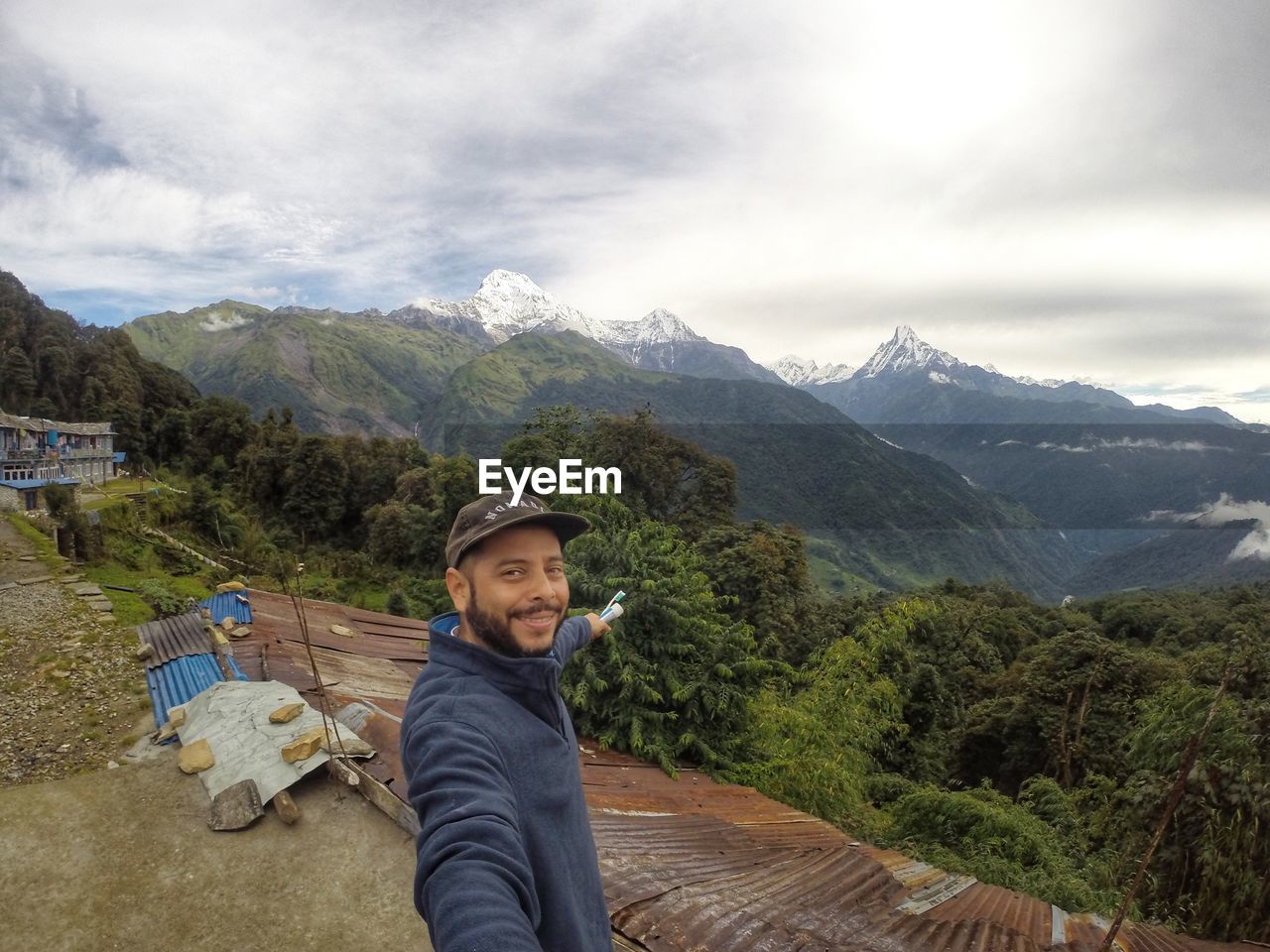 Portrait of man against mountains and cloudy sky