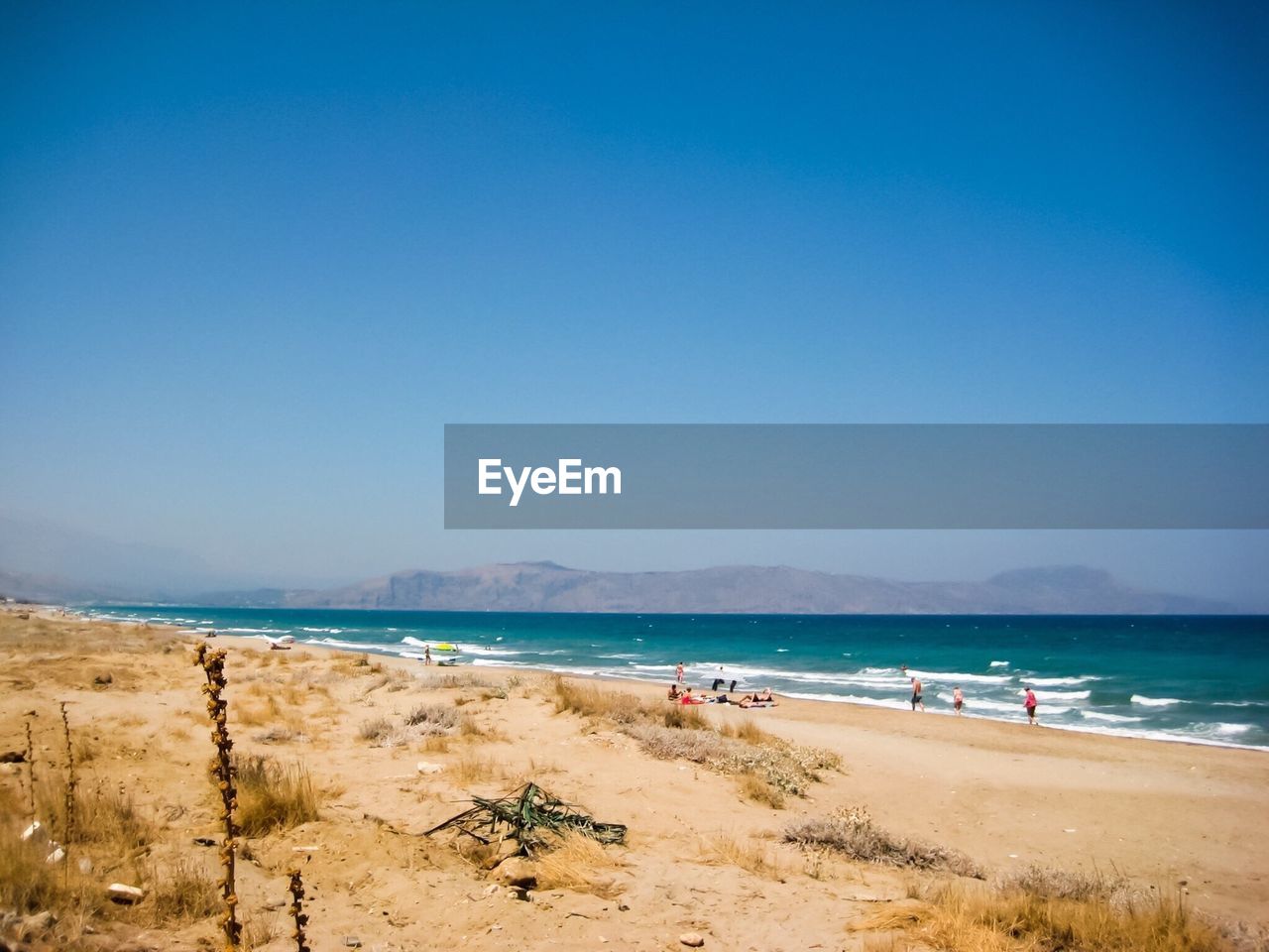 Tourists on beach against sky