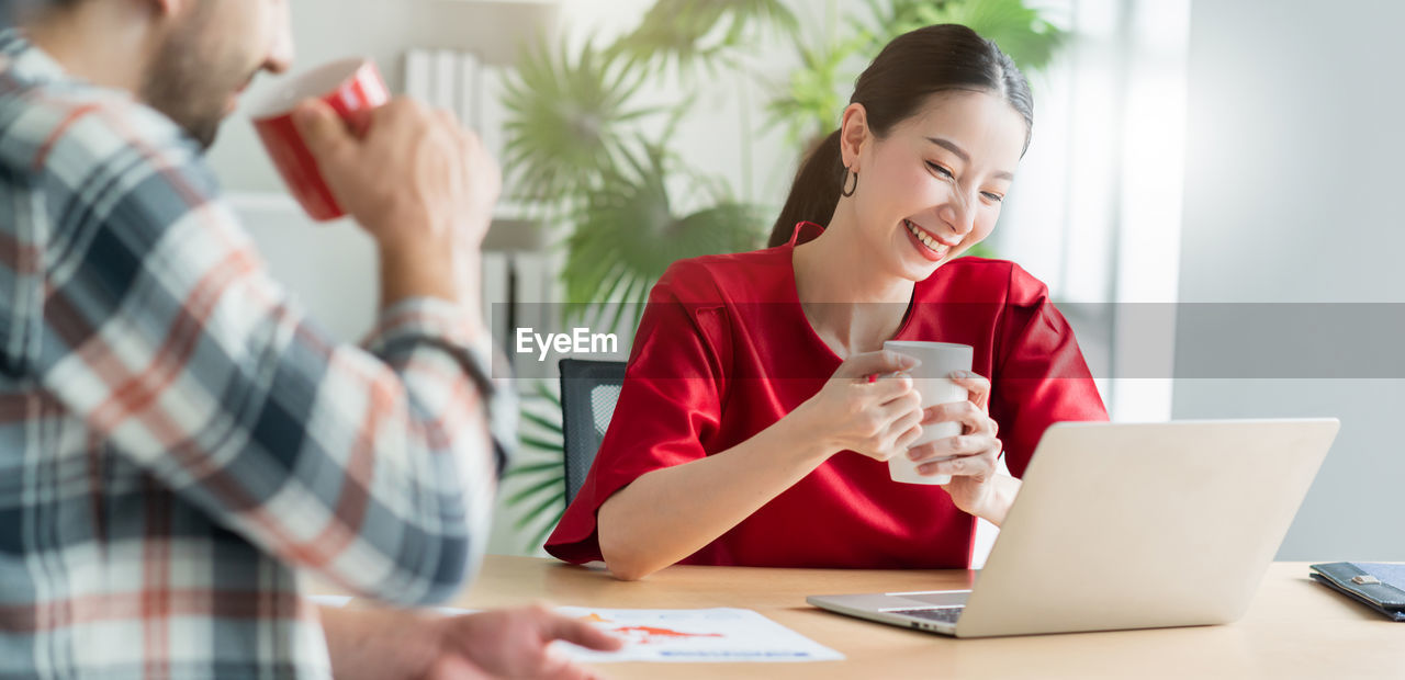 Smiling businesswoman looking at laptop