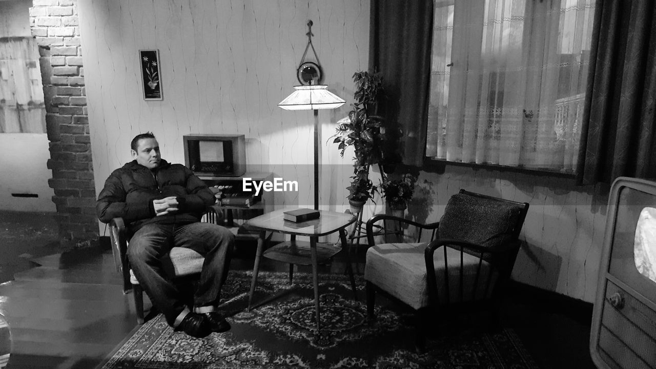 Man sitting on chair in living room