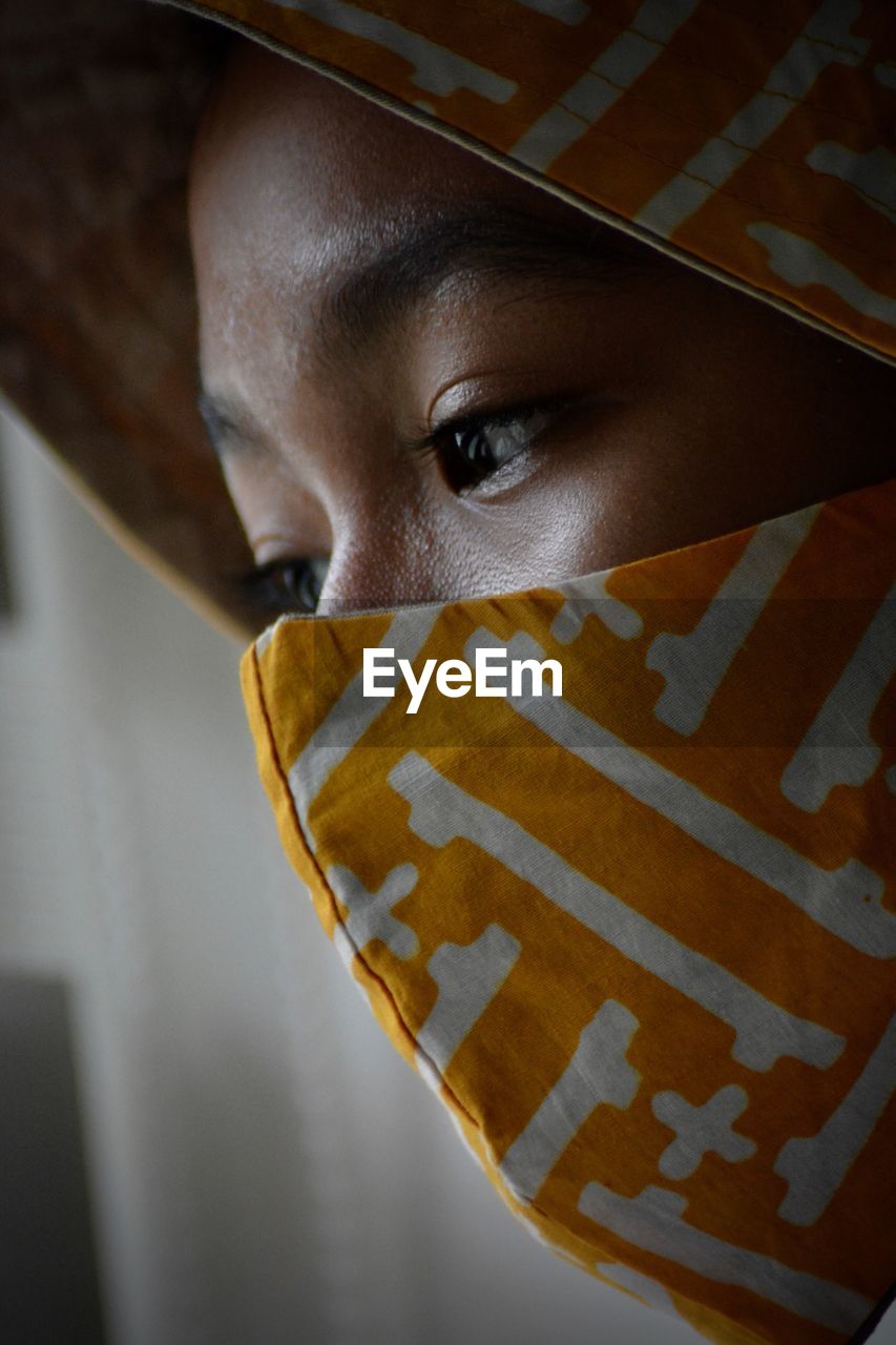 Close-up portrait of a young woman covering face