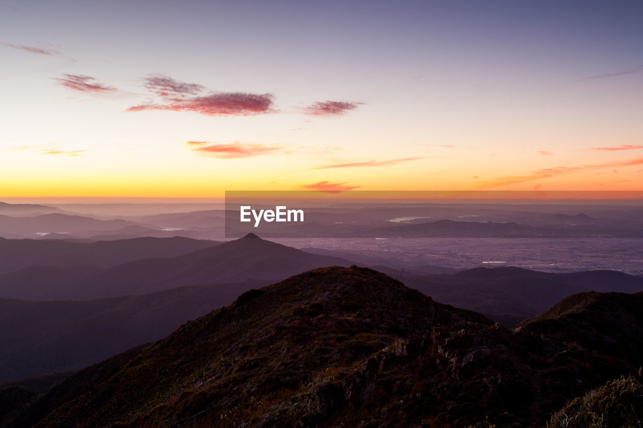 SCENIC VIEW OF SILHOUETTE MOUNTAIN AGAINST SKY AT SUNSET