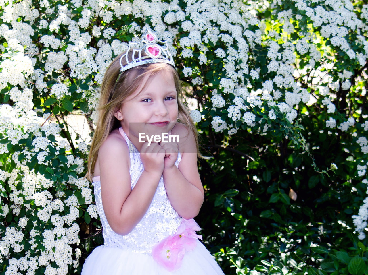 Little girl in a princess costume with toy tiara, is happy to be a young pretend royal
