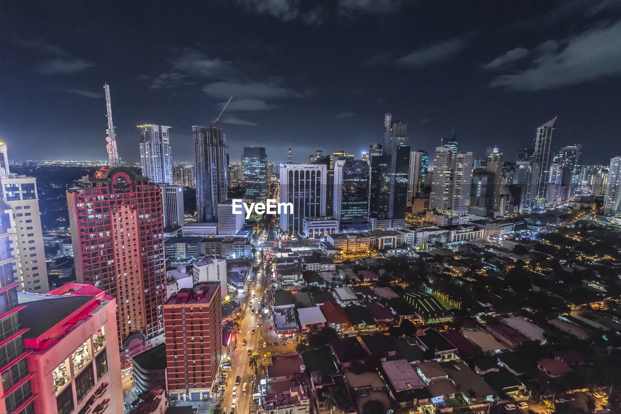 Cityscape against cloudy sky at night