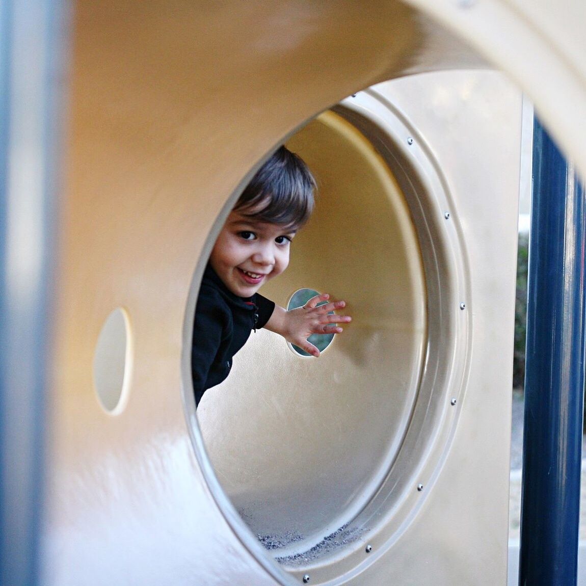 Portrait of smiling boy in play equipment at park