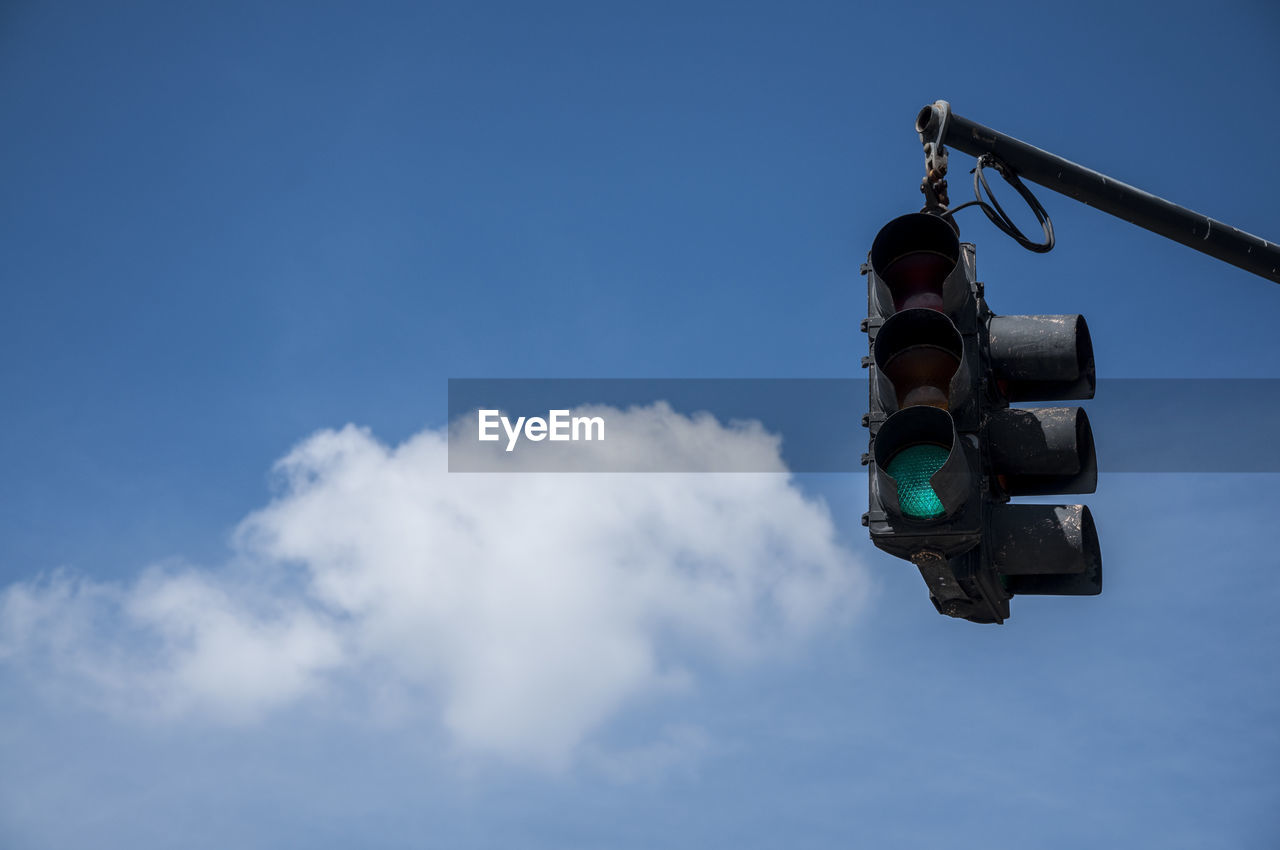Low angle view of stoplight against blue sky