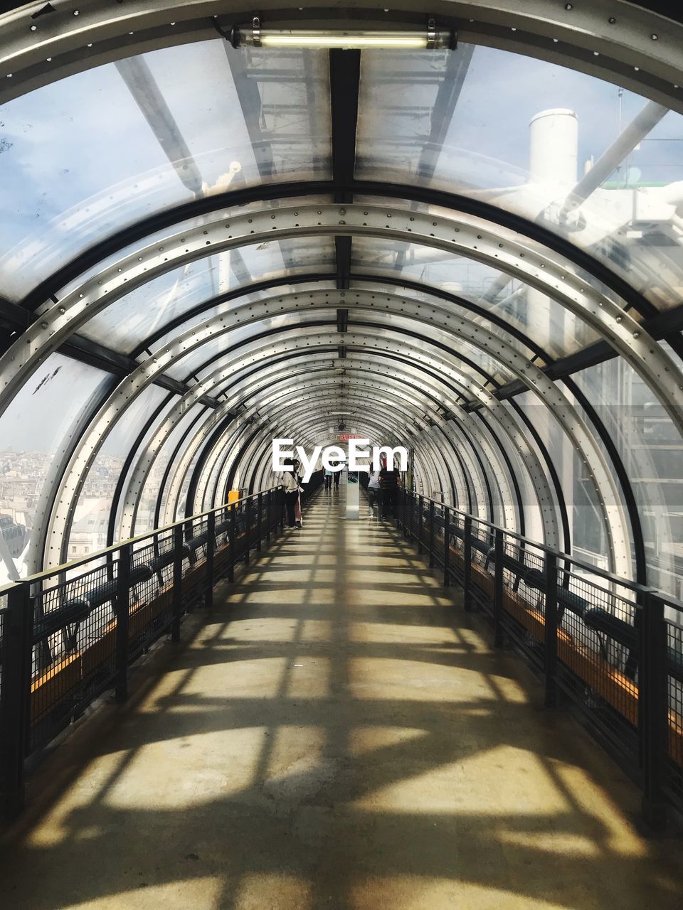 VIEW OF PEOPLE WALKING IN ILLUMINATED UNDERGROUND WALKWAY