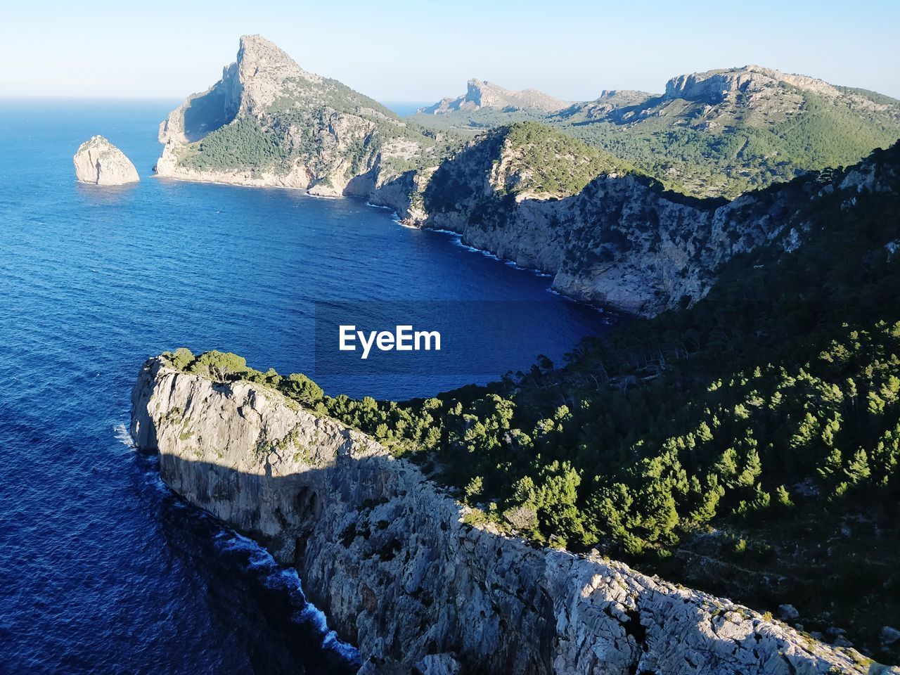 High angle view of sea by mountain against sky