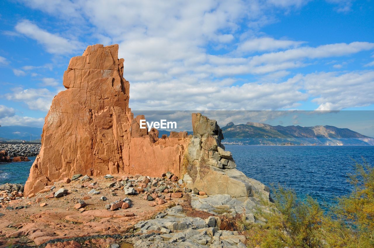 Rock formations by sea against sky