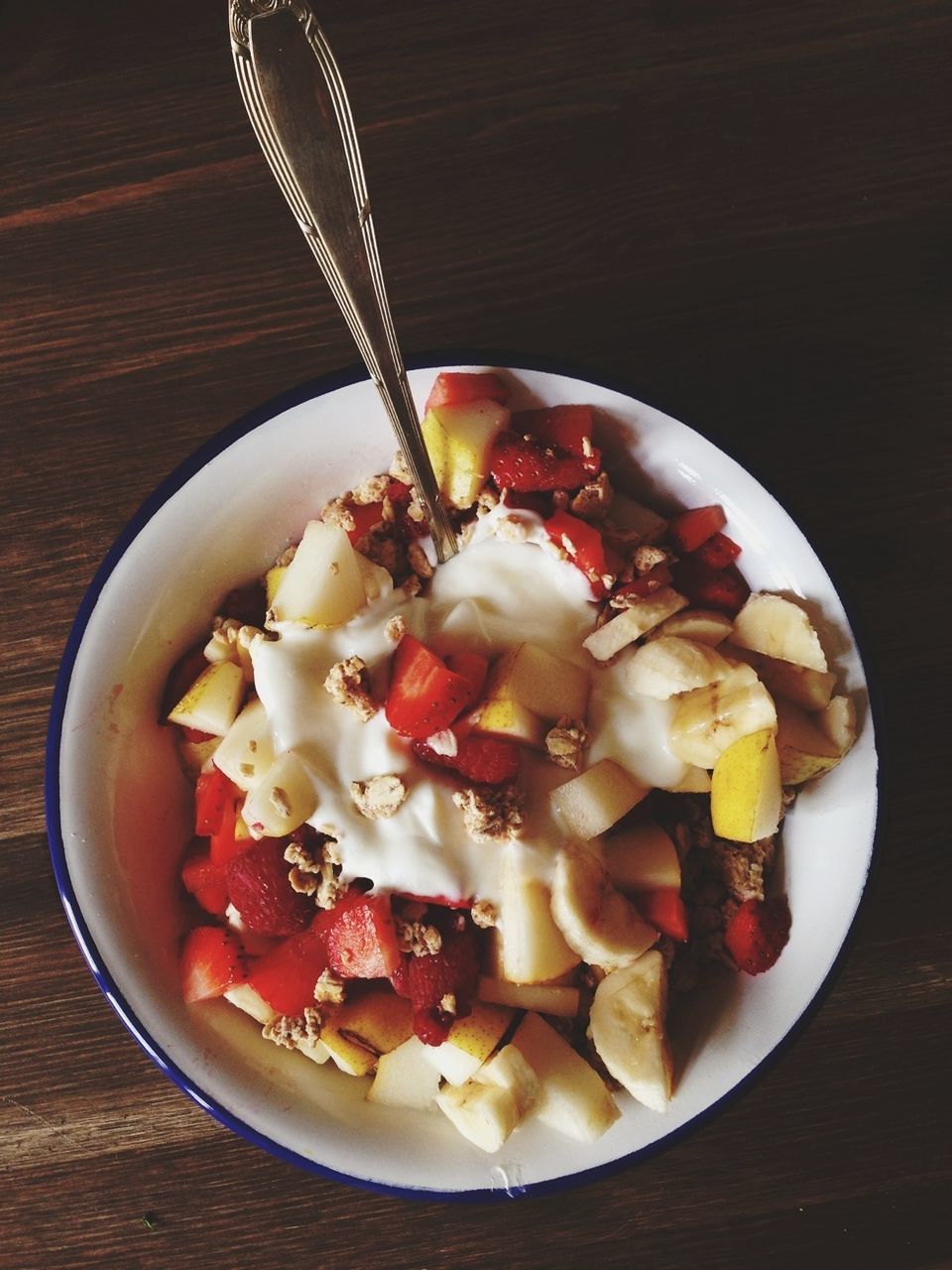 Bowl of cereal with fruits on table