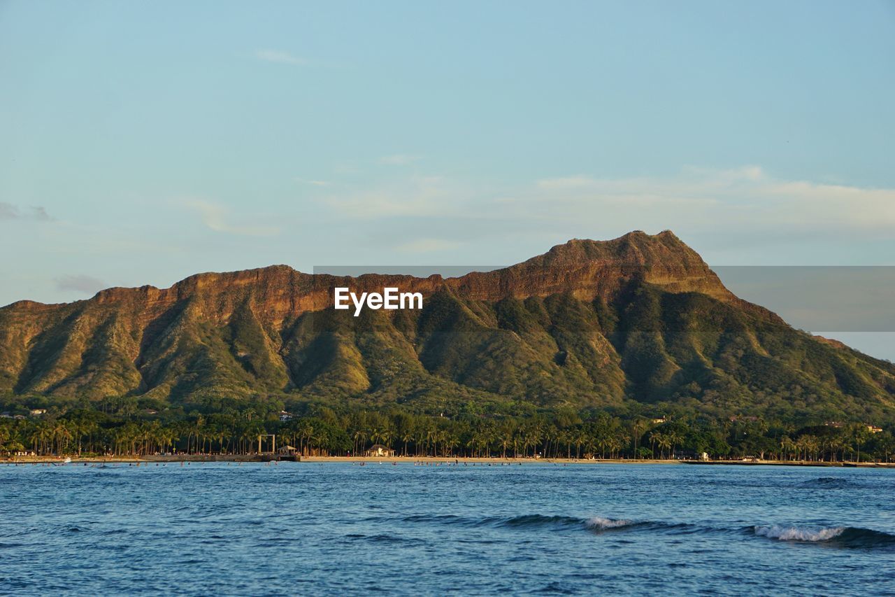 Scenic view of sea and mountains against sky