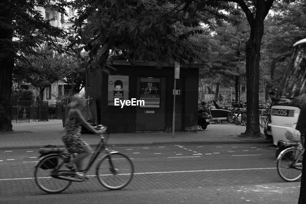 MAN RIDING BICYCLE ON STREET AGAINST CITY