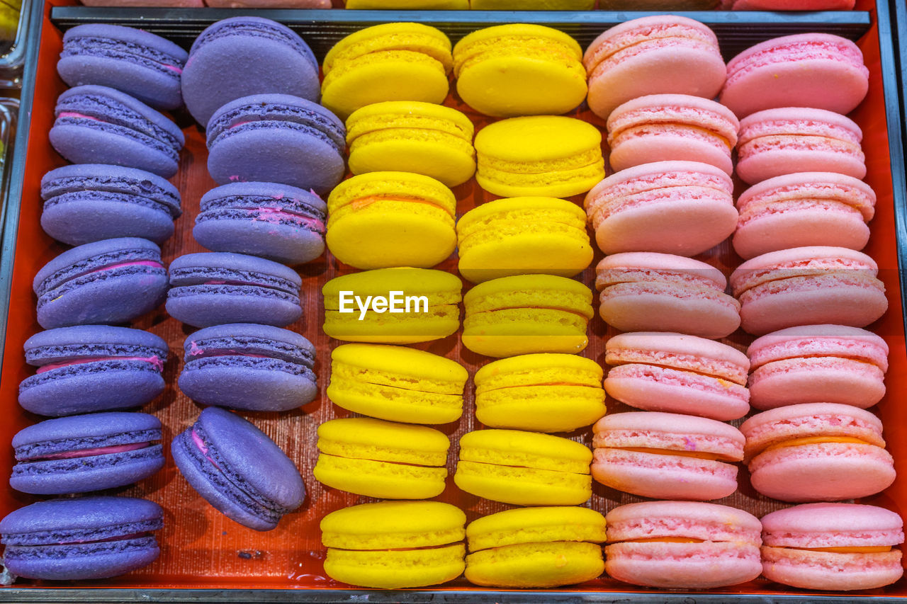 Colorful macaroon cakes in tray for sale at bakery