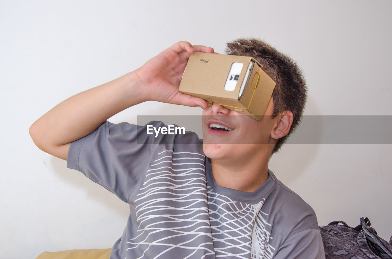 Boy watching virtual reality against white background