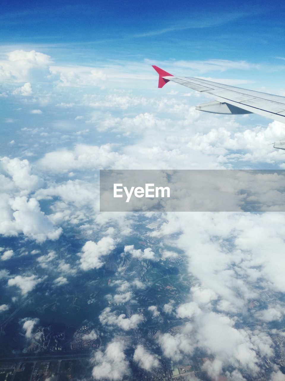 AERIAL VIEW OF AIRCRAFT WING OVER CLOUDS