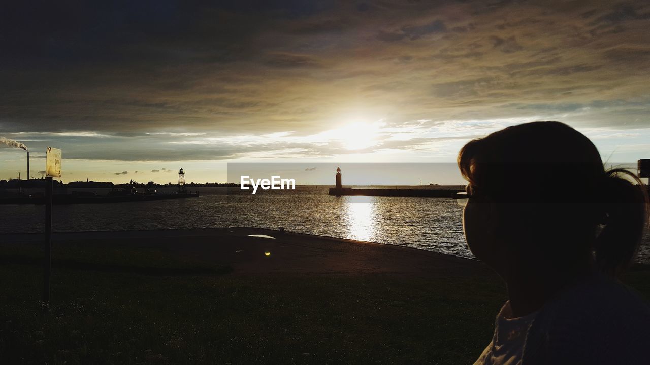 Side view of mature woman at harbor during sunset