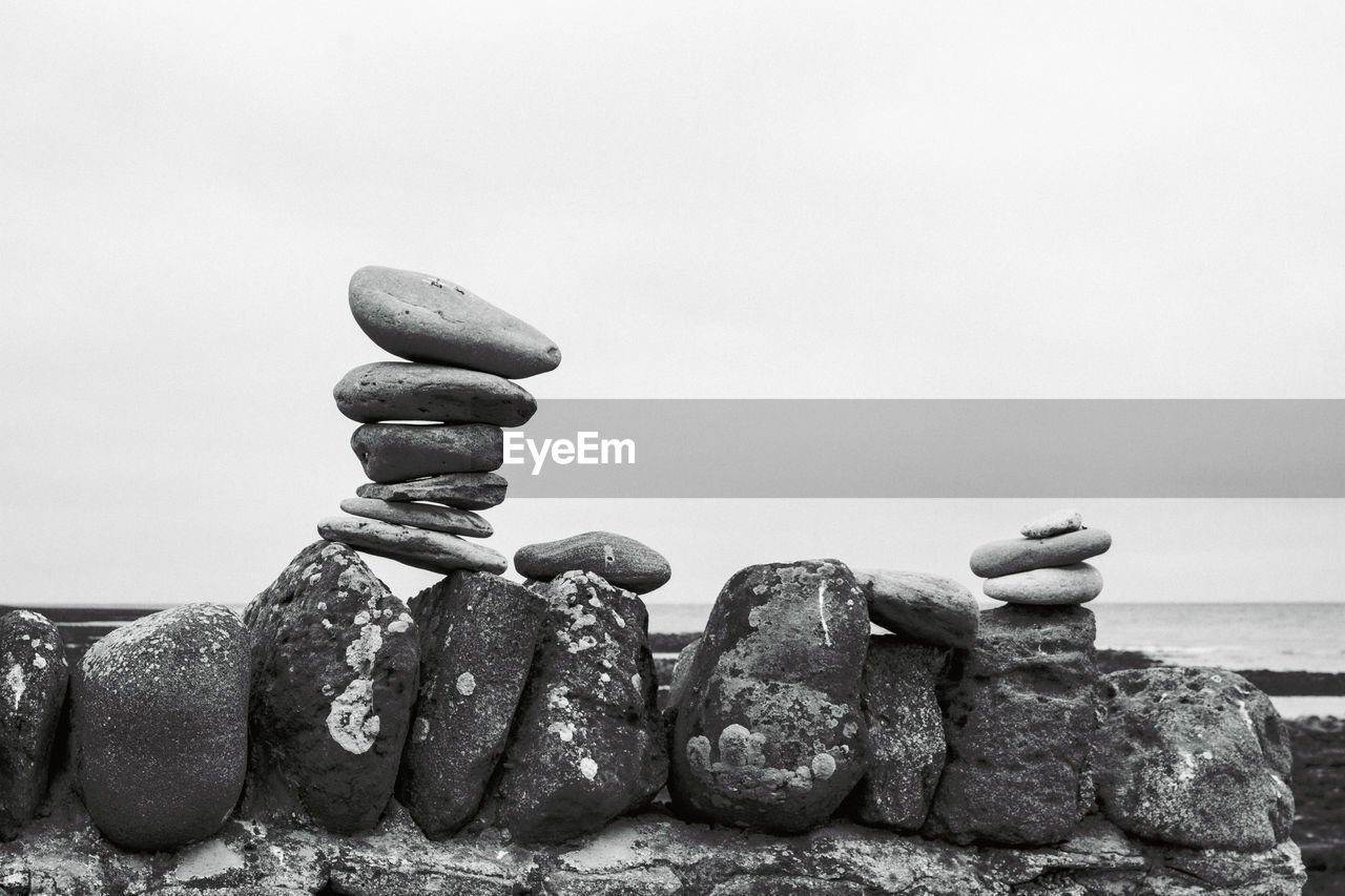 Stack of stones on beach against clear sky